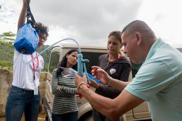 People learning to use a water filtration system