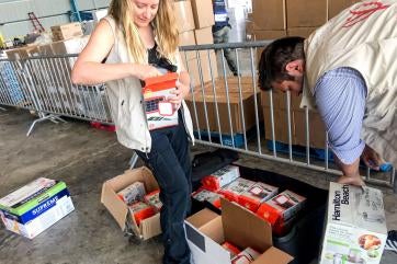 Prosper global employees unpack solar lanterns in a warehouse.