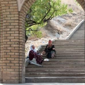 Two people sitting on stairs outside