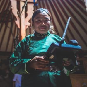 A mongolian animal herder uses an sms forecasting system device to monitor local weather.