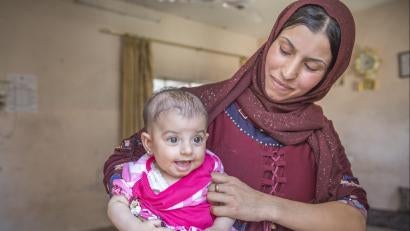 Diana (right) shares a shelter with her husband, Hatem, his parents, their two baby daughters Sidra and Asil, and several other family members. The house is standing, but badly damaged. With cash from Prosper Global, the couple purchased clothes, food and milk for Sidra, who has a disability and can’t eat solid food.
