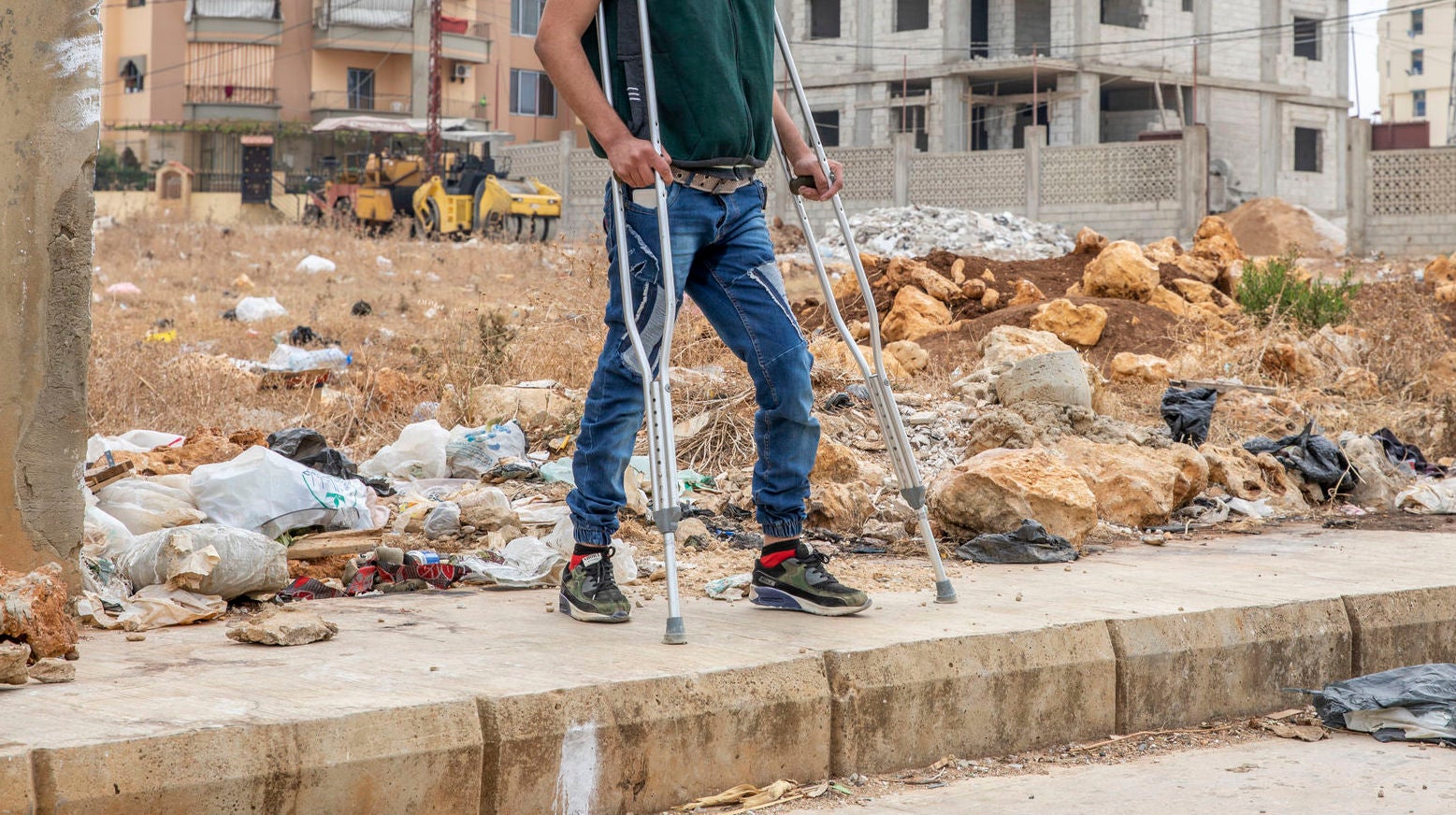 disabled individual standing in front of empty lot.