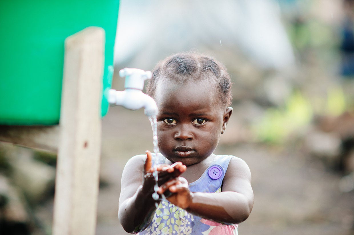 A child washes hands at a hygiene station in a displacement camp on the outskirts of Goma, DRC. In 2015, when this photo was taken, about 5,000 people lived in the camp because of ongoing violence and political instability in eastern Congo. Photo: Corinna Robbins/Prosper Global