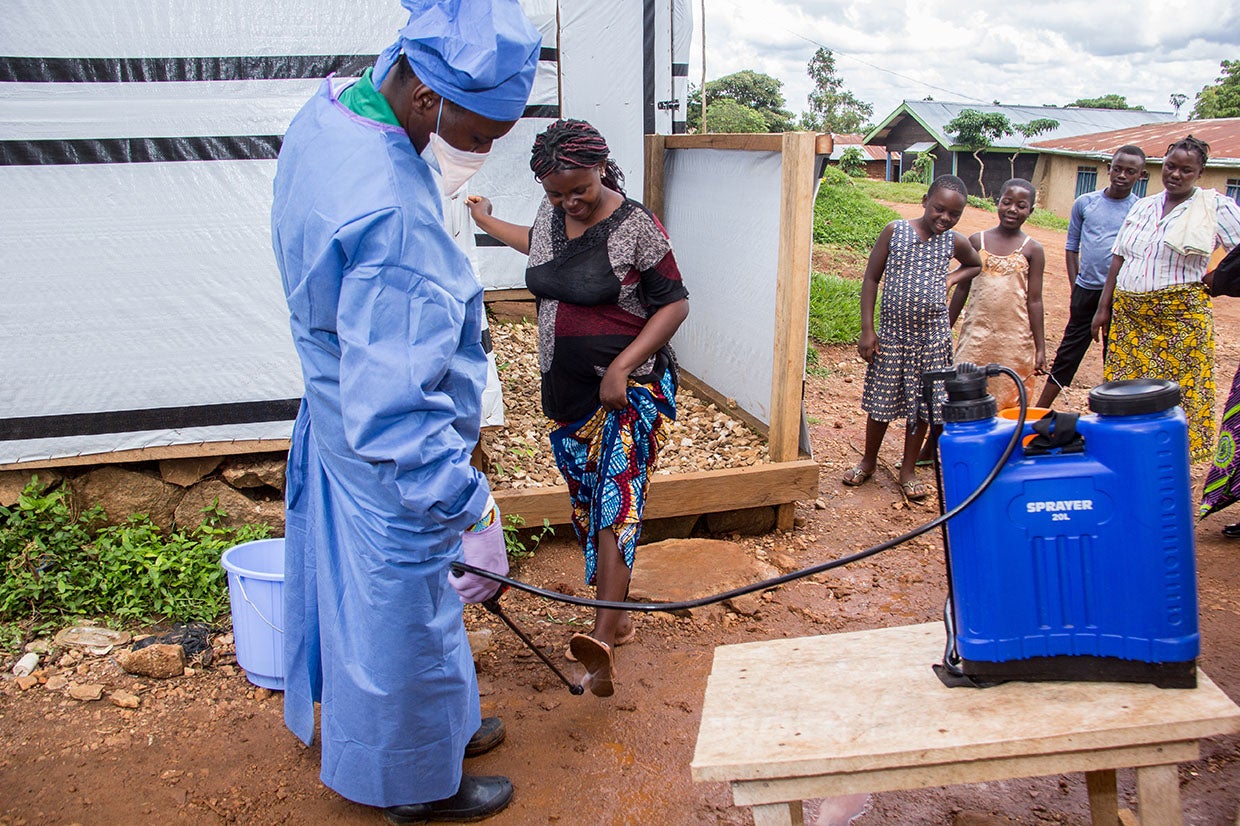 Prosper Global supports the Malepe Health Center in DRC with chlorine and hand washing kits to disinfect hands before entering. This measure is very effective for the prevention of Ebola. Kavira, 23, pregnant with her first child, comes to the health center for an antenatal clinic. Her feet are disinfected before entering. Photo: Rudy Nkombo/Prosper Global