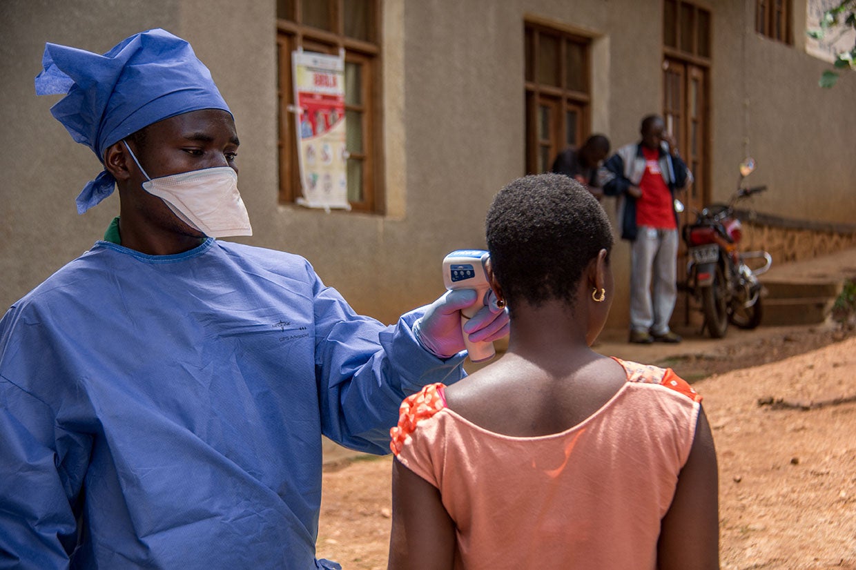 Habibu, hygienist at the Malepe Health Center in DRC, takes the temperature of every person who enters the health center after attending our training about preventing the spread of the Ebola virus epidemic. Photo: Rudy Nkombo/Prosper Global