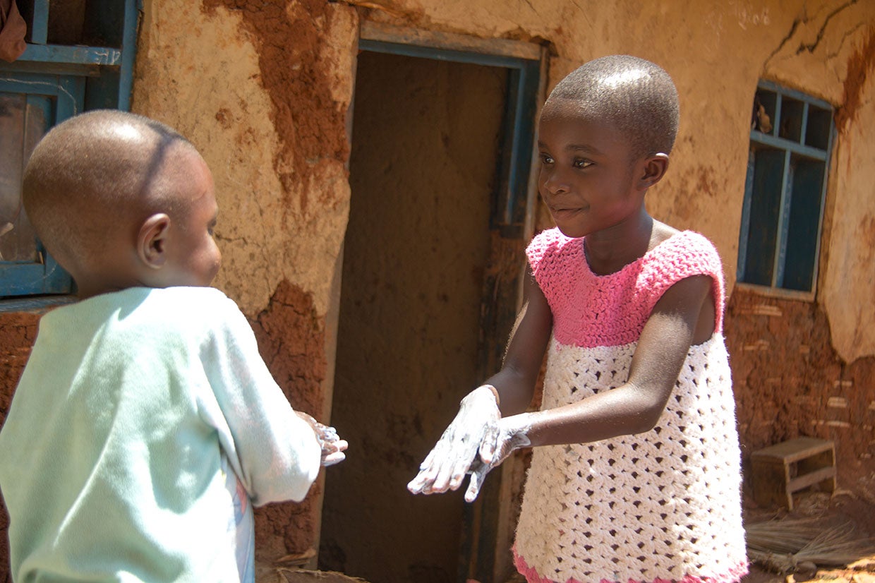Christine, 6, and her little brother Gabriel, 3, practice their hand washing techniques. Photo: Rudy Nkombo/Prosper Global