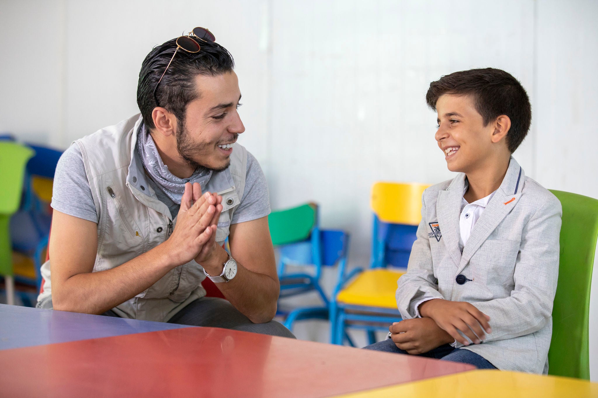 At a youth center in Zaatari, Omar Al-Tal sits with Mohammad. Mohammad is able to play sports and games while learning important life skills like computers and English. Two of Mohammad’s favorite activities are playing foosball and soccer, but his favorite is singing. At a recent talent show in the center, he finished third. Photo: Ezra Millstein/Prosper Global