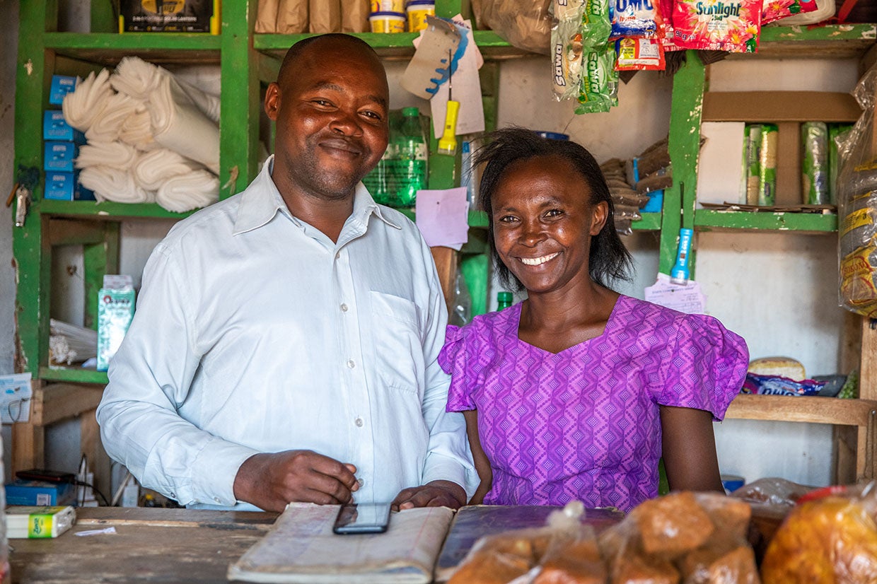 Lydia and her husband at their small shop. Lydia relies on rain-fed agriculture to support her family, a livelihood that has become increasingly fragile with the growing effects of climate change. Photo: Ezra Millstein for Prosper Global