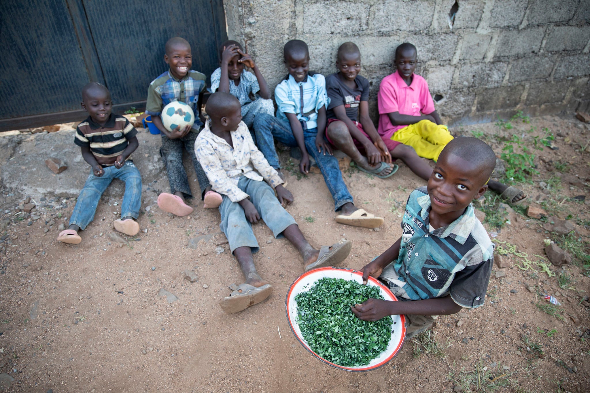 Eight children pictured in Nigeria. Their caretaker has struggled immensely to feed them with what she can grow and cultivate herself on land she pays to rent. Photo: Ezra Millstein/Prosper Global