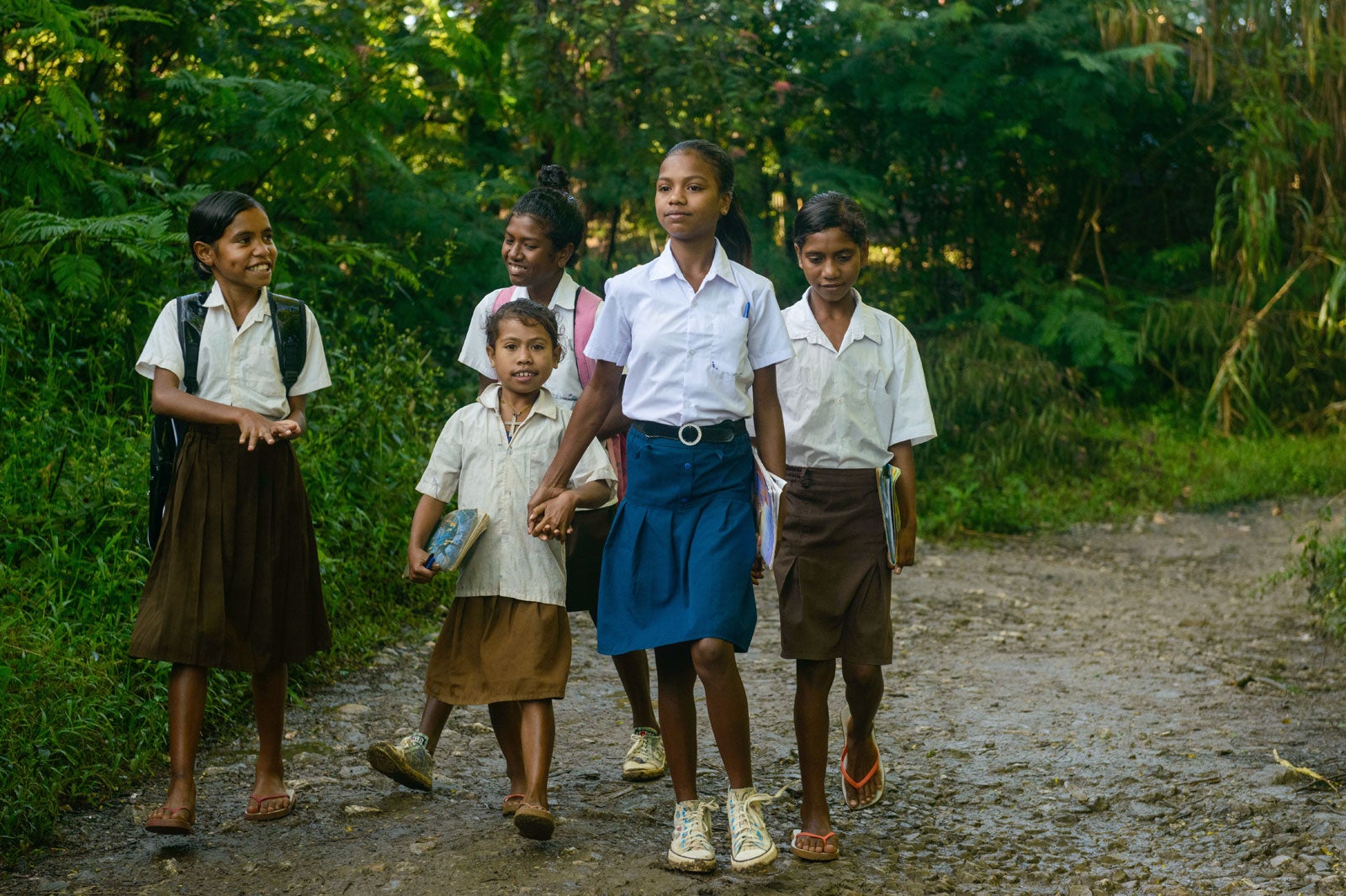 Lourdes walks to school in the company of younger classmates in Timor Leste