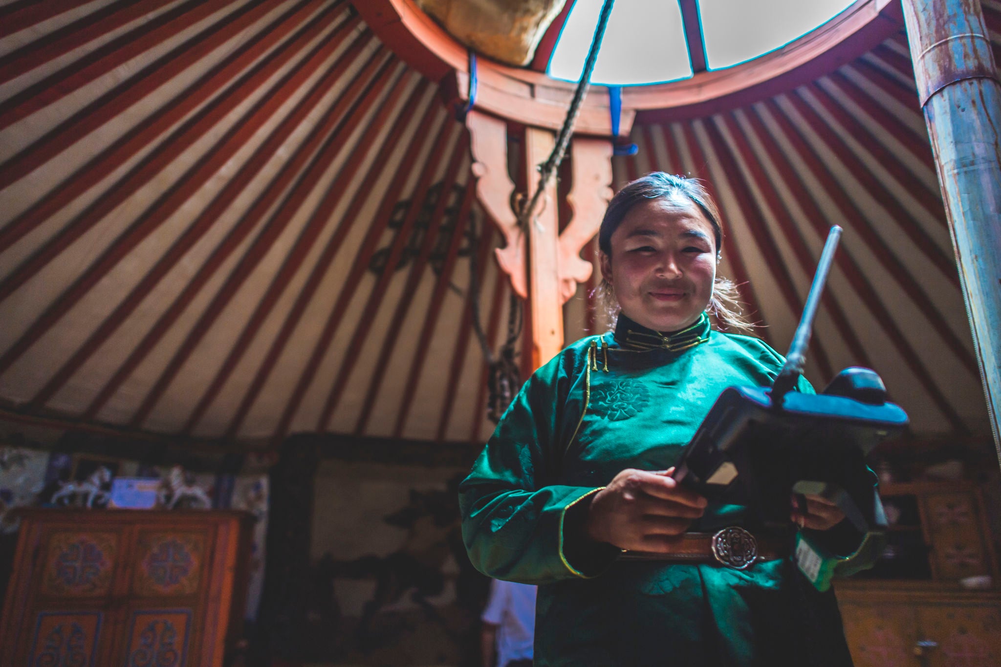 A Mongolian animal herder uses an SMS forecasting system device to monitor local weather.