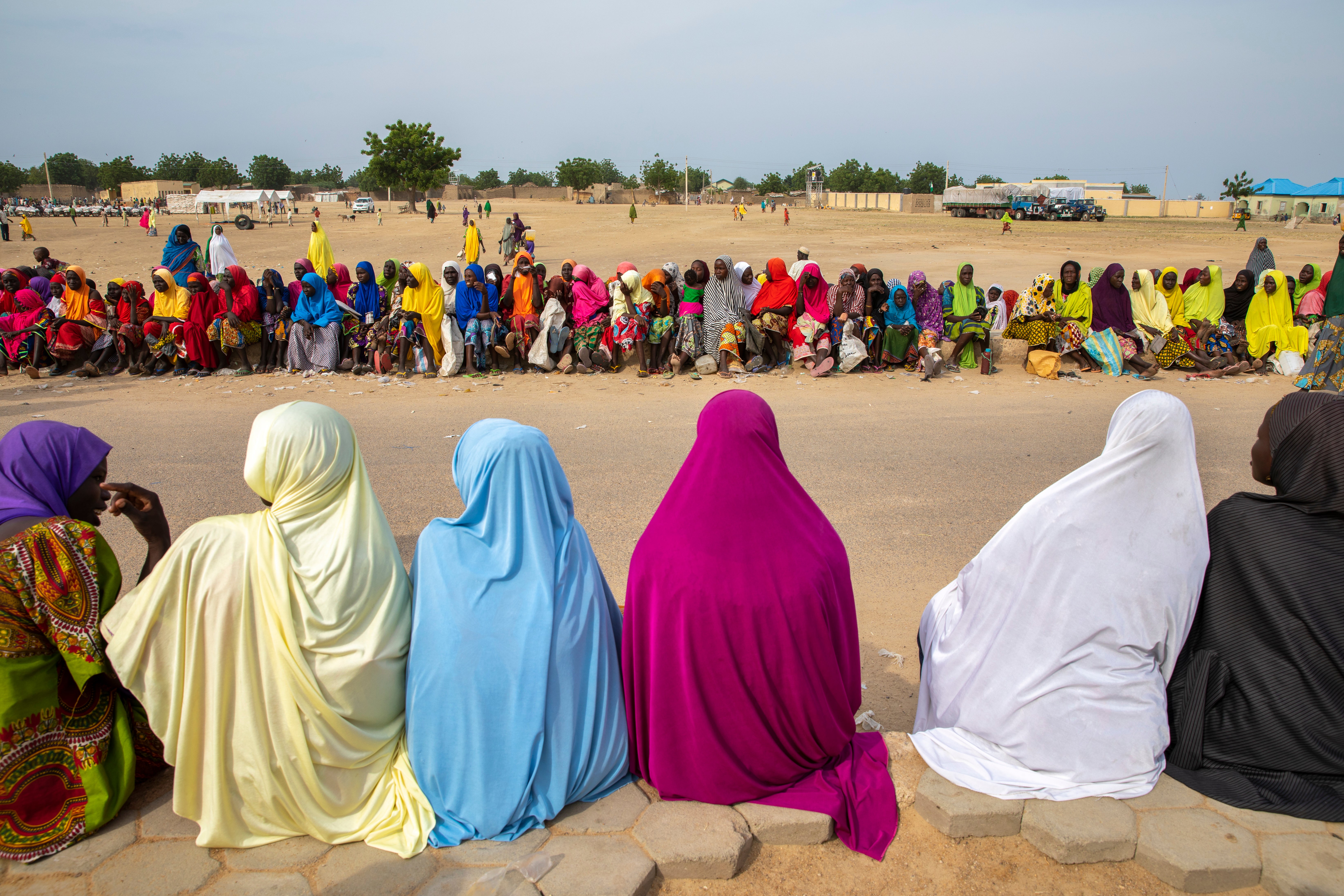 Women and children wait in line for a monthly food distribution in Fulatari camp.
