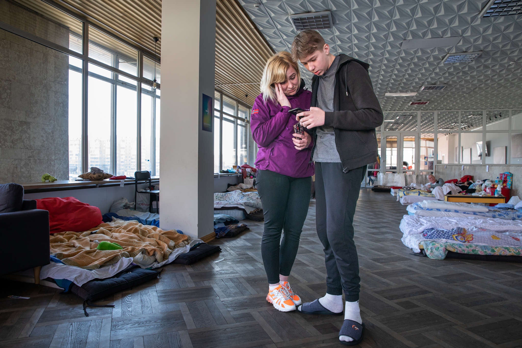 Two people reading a text message on a mobile device.