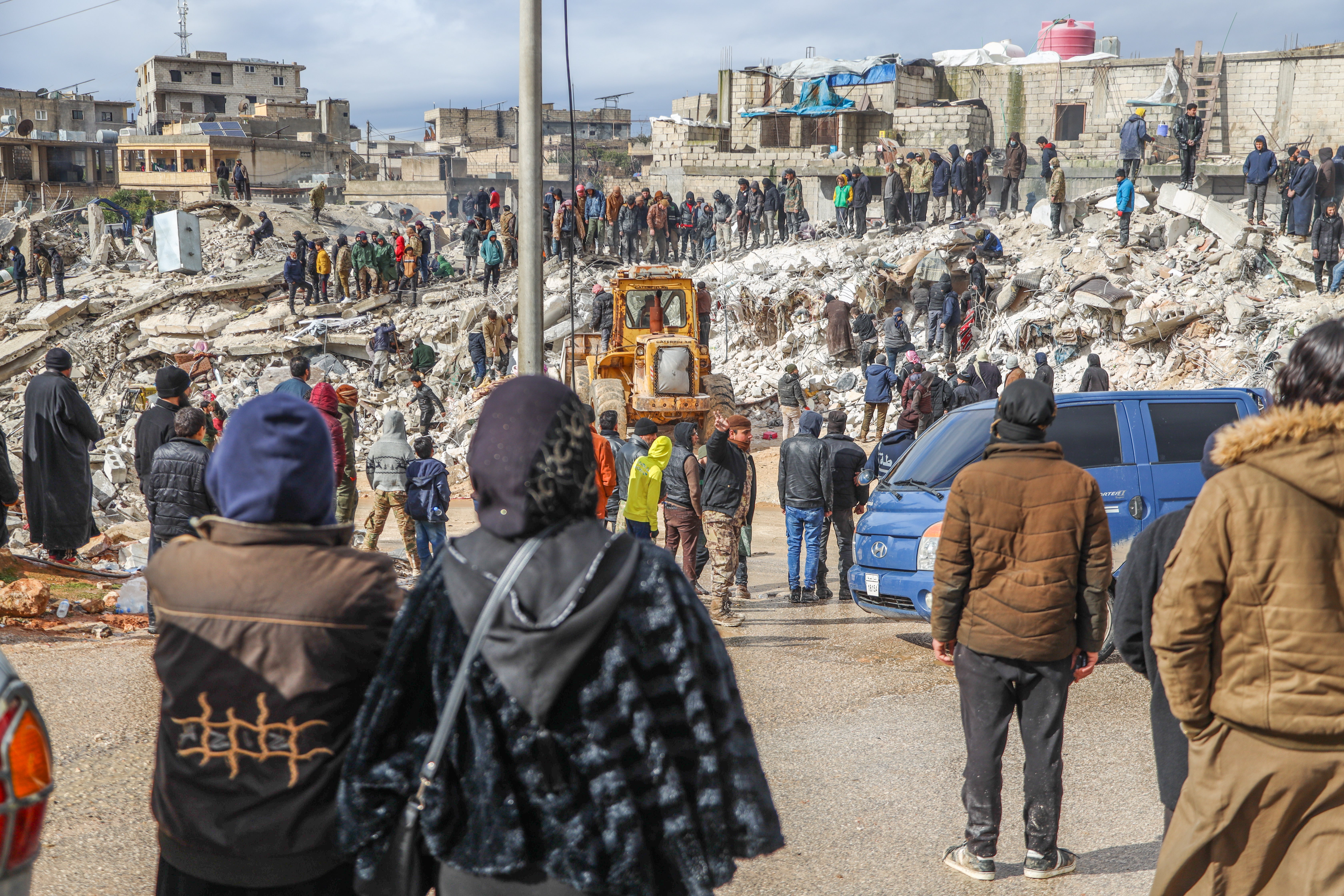 In Harim Syria, people and rescue crews gather around collapsed buildings following the 7.8 magnitude earthquake.