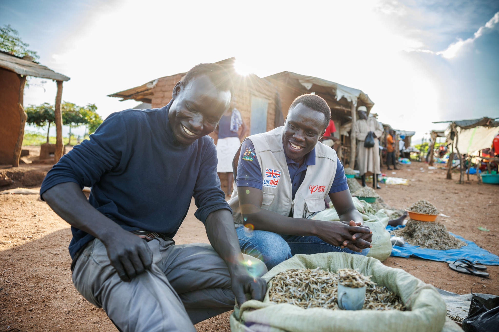 A Project Officer for Prosper Global, talks to Festo James, a South Sudanese refugee and beneficiary of the DREAMS Program.