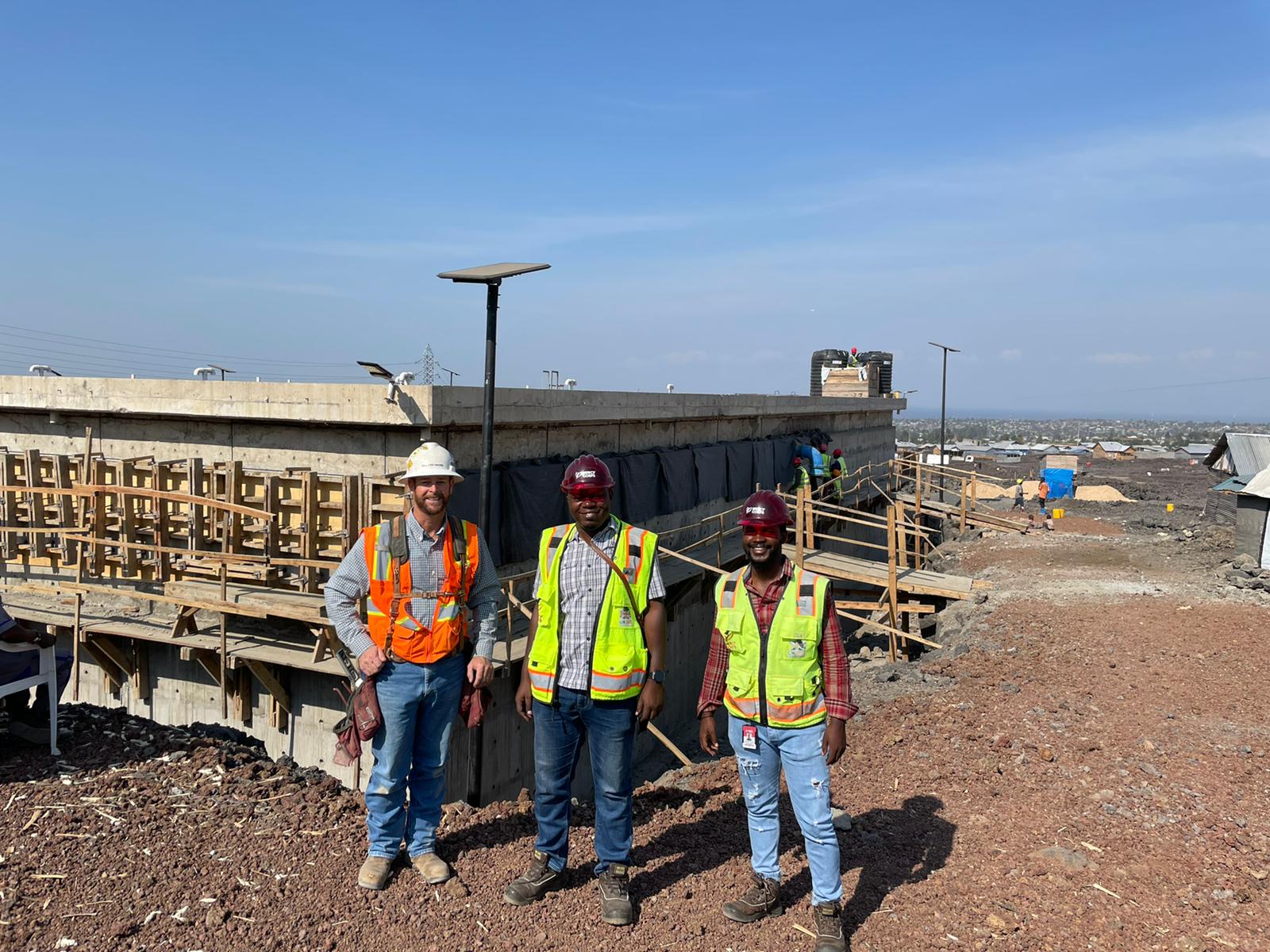 In DRC, three members of the Prosper Global’s infrastructure team pose together, including engineer Simeon Kakule (center).