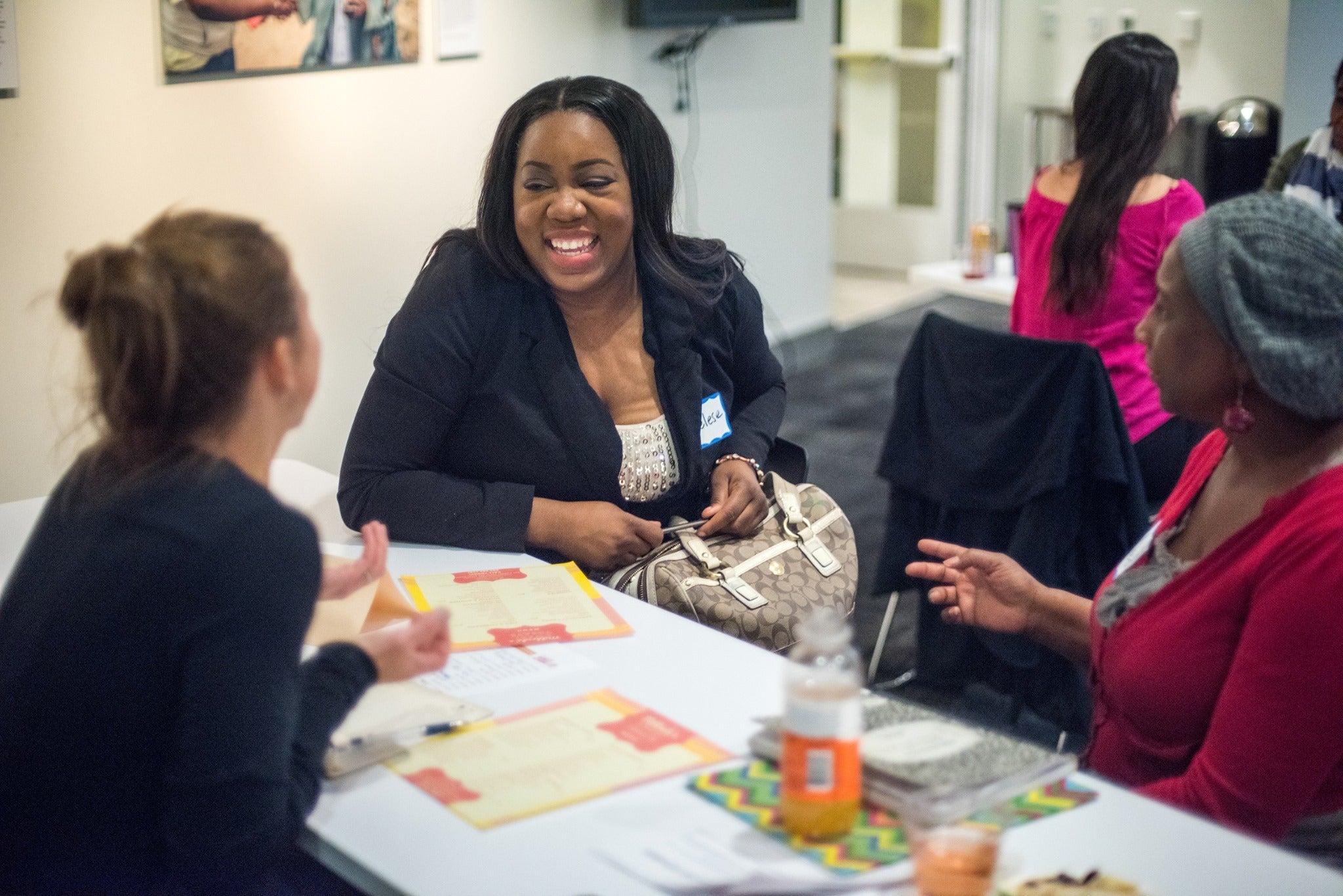 three women sitting at a table laughing