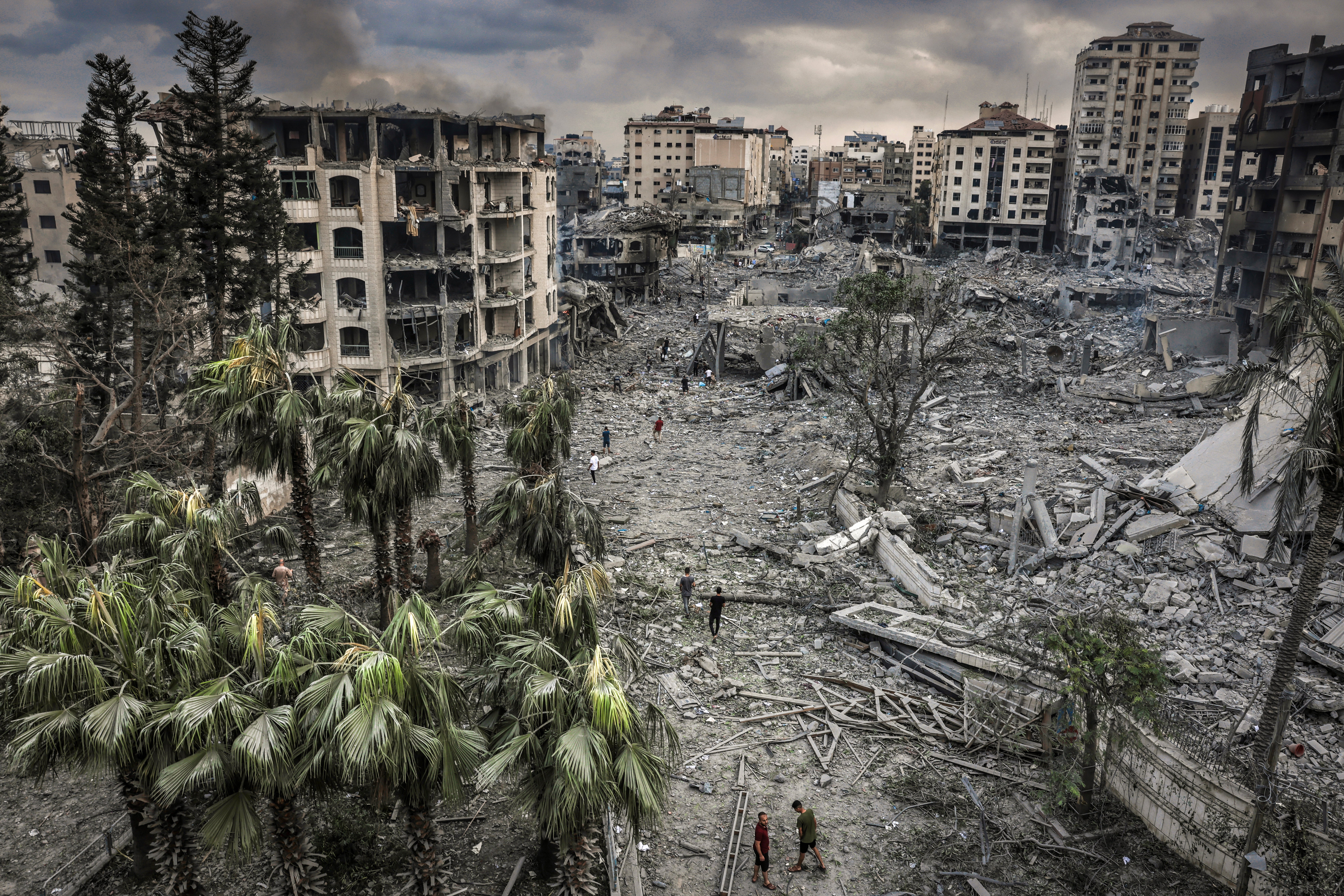 Residents walk through the rubble of the Al-Remal neighborhood in Gaza City after it was destroyed by air raids. © Eyad Baba for Prosper Global