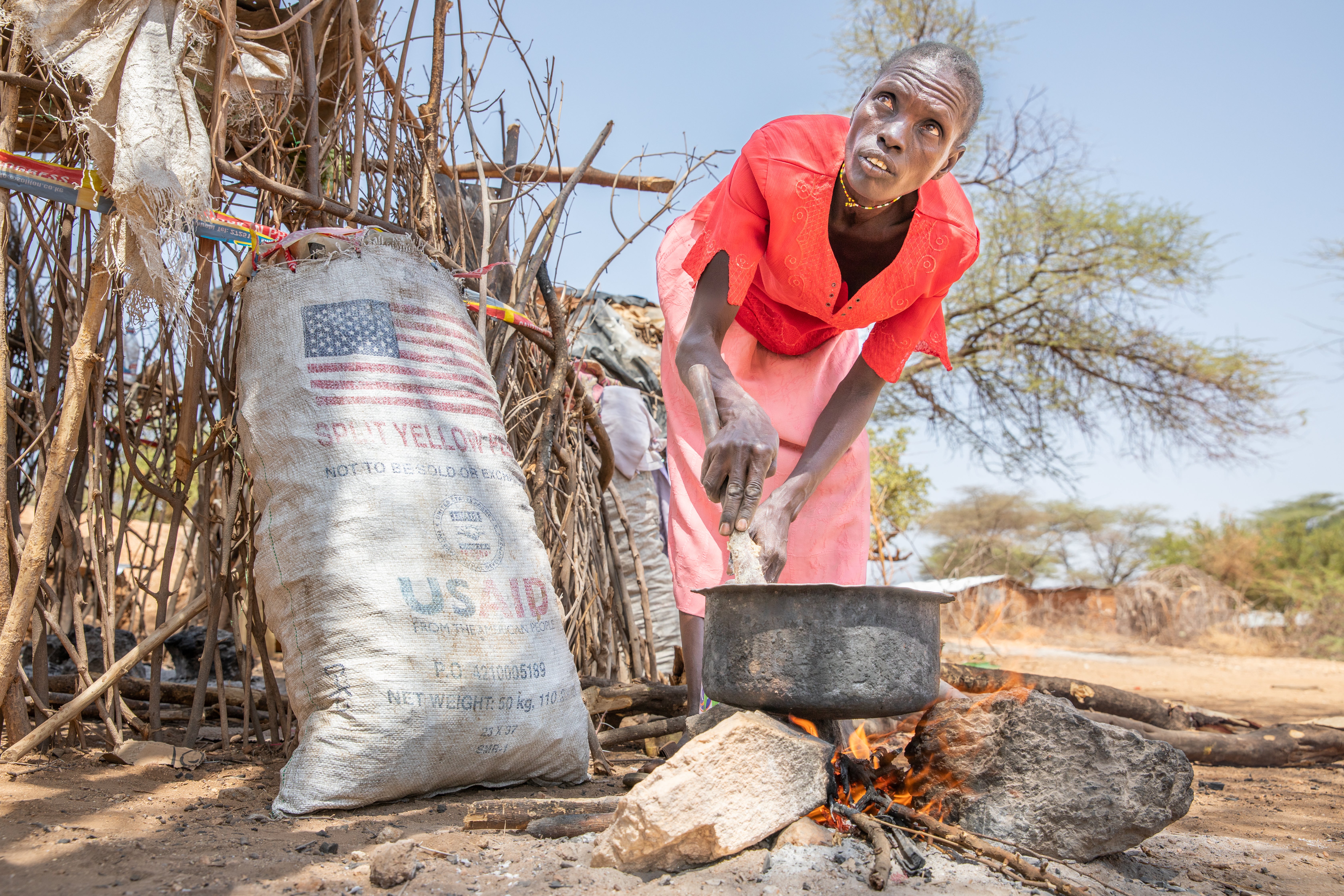 Kenyan woman cooking outside.