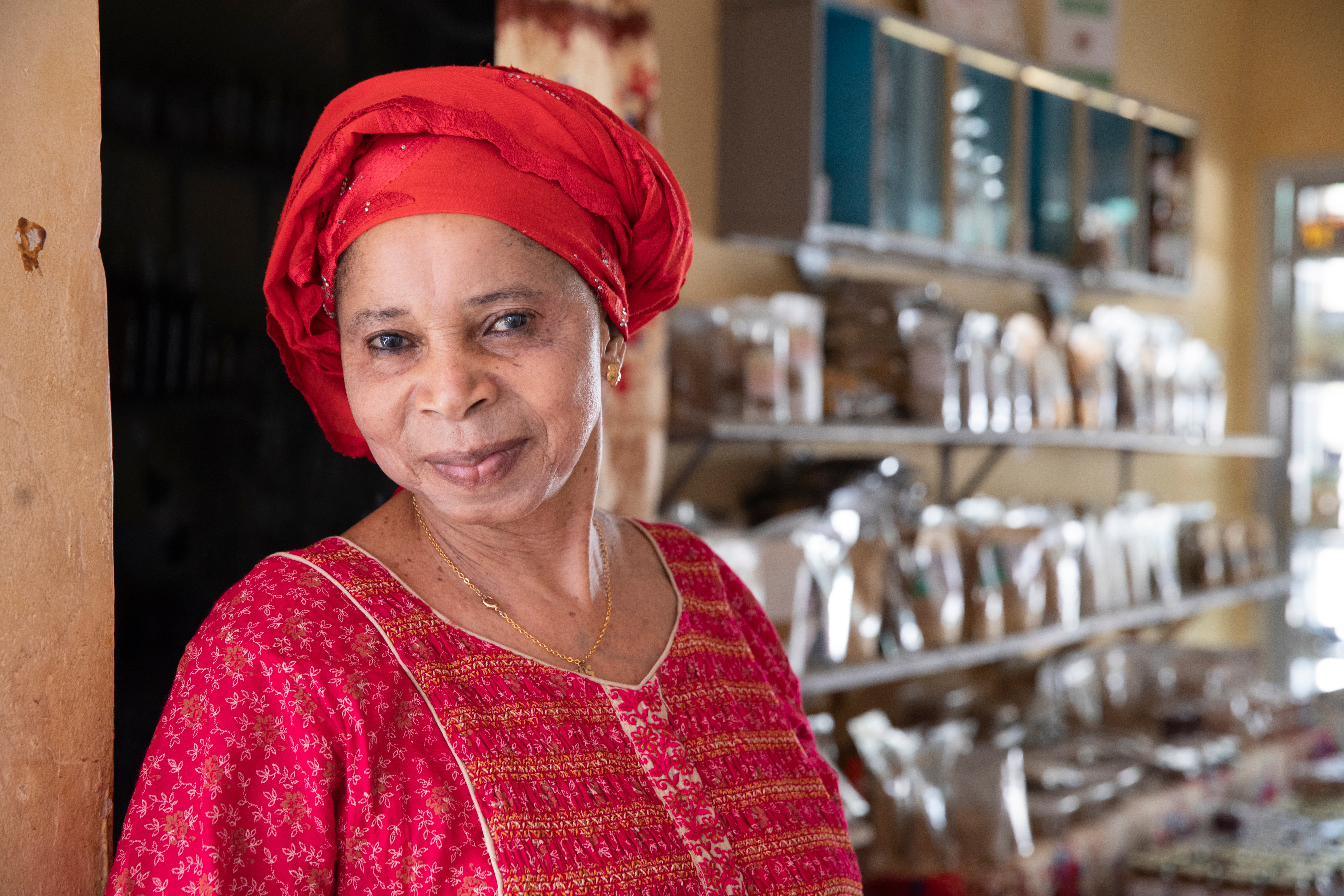 Senegalese female entrepreneur stands in her business smiling.