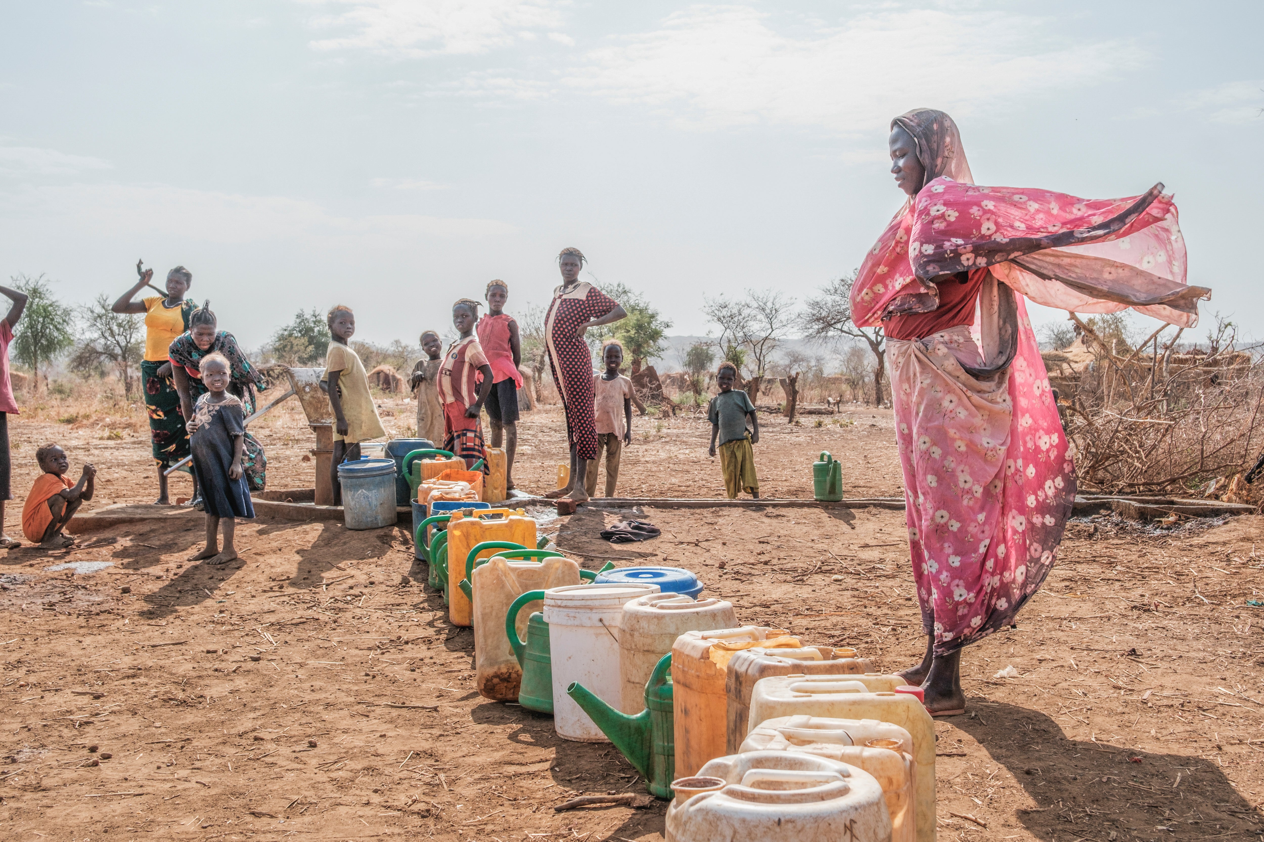 Women gather at a water pump in Thobo camp, where tens of thousands of people displaced by the war in Sudan are now living.