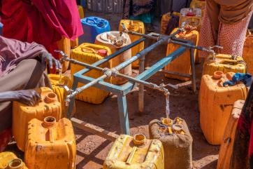 February 2022, baidoa, somalia. families fill jerry cans at a water point built by prosper global at the loojele idp camp near baidoa. 