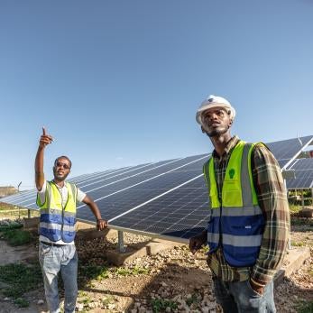 Ethiopian technications standing in front of a solar array.