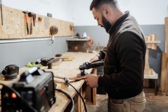 Man working at bench with tools.