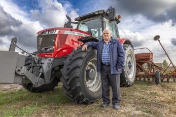 Man standing in front of tractor.