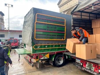 Two men unload a supply truck in lebanon