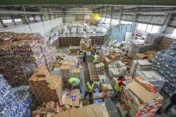 A warehouse with Prosper Global staff and volunteers packing 1,300 food kits.