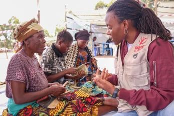 Prosper Global DRC team member speaks with community member in DRC.