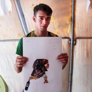 A young man pictured holding his collage.
