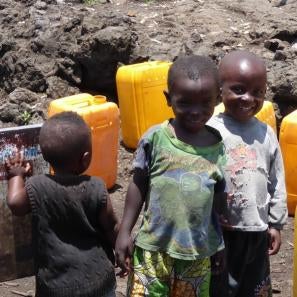 Image of three young boys with yellow water containers