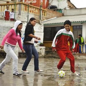 Colombian children playing soccer in the rain