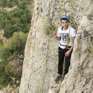 Mohammad khaldoun takes a short rest before completing the climb. prosper global staff take syrian refugee youth rock climbing, among other wilderness therapy activities. all photos isidro serrano selva for prosper global.