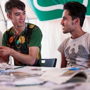 Two young men seated side by side at a table