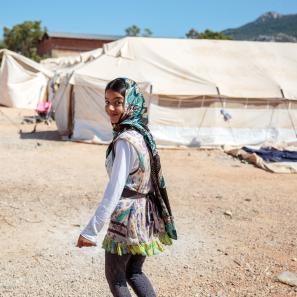 Girl in greece walking near white tents