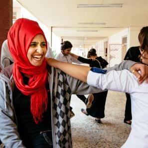 Youth smiling and holding each other by the arm