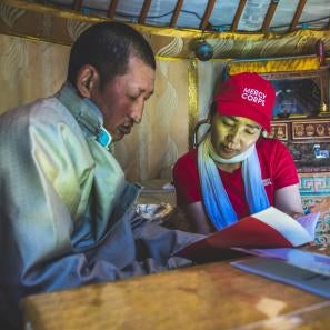 Mercy corp team member reviewing materials with community member
