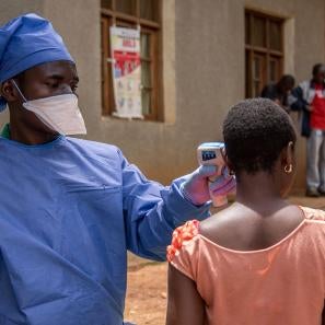 Habibu, hygienist at the malepe health center in drc, takes the temperature of every person who enters the health center after attending our training about preventing the spread of the ebola virus epidemic. photo: rudy nkombo/prosper global