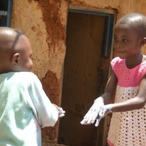 Christine, 6, and her little brother gabriel, 3, practice their hand washing techniques. photo: rudy nkombo/prosper global