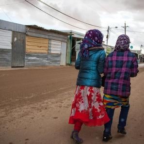 Image: two girls walking from behind in za'atari camp for syrian refugees