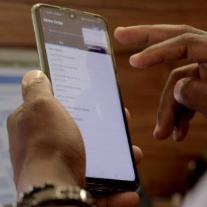 A pair of hands uses a mobile device.