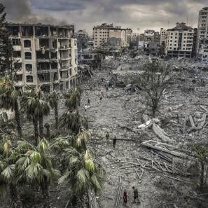 Residents walk through the rubble of the al-remal neighborhood in gaza city after it was destroyed by air raids. © eyad baba for prosper global