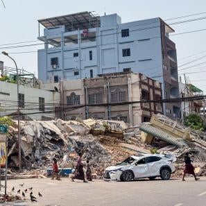 Urban scene, with destroyed building in background.