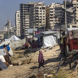 A woman walks between tents in gaza city.