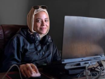 Palestinian woman sitting at computer in Gaza Sky Geeks office.